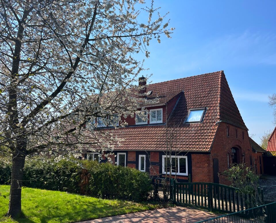 Kanzleigebäude Kanzlei am Deich, ein Backsteinhaus mit Kirschblüten